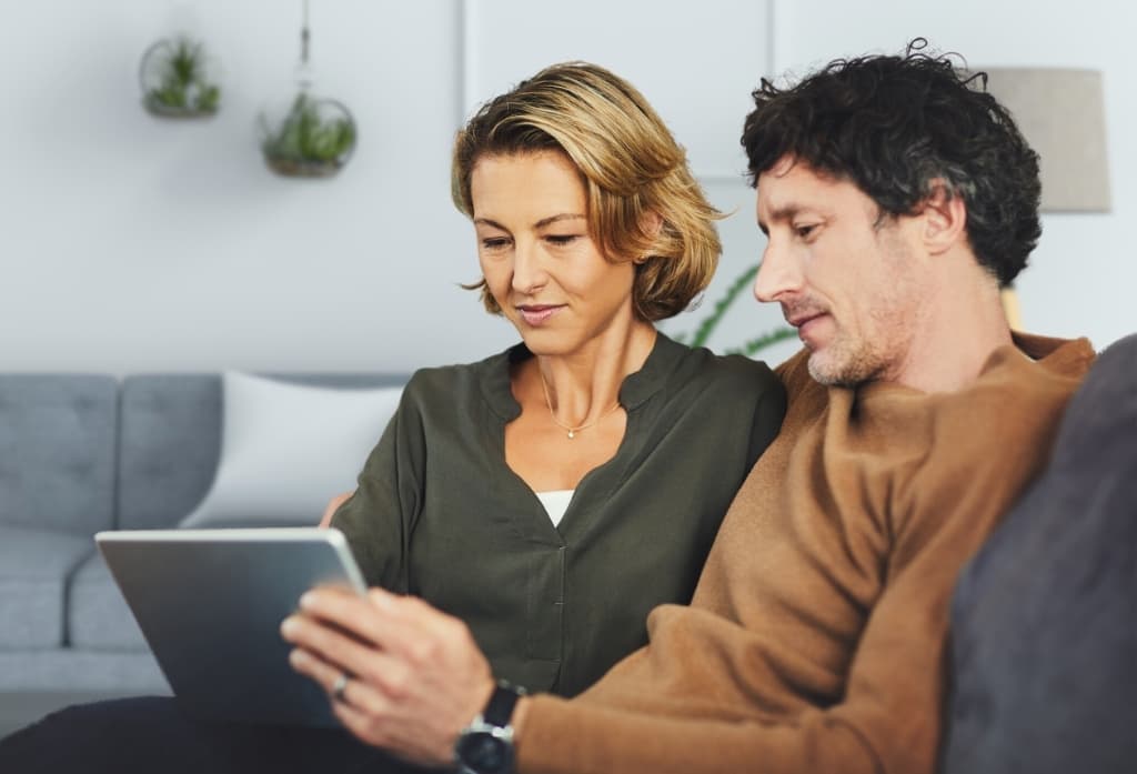Ein Paar schaut gemeinsam auf ein Tablet.
